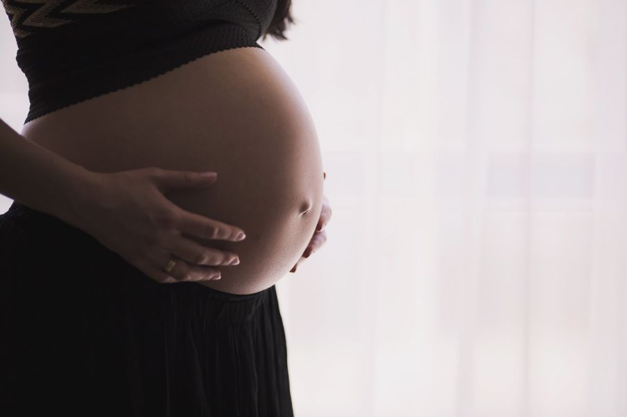 Tehotná žena si drží odhalené brucho